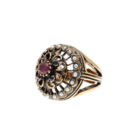 Anello Rosone Alcozer in ottone dorato con microperle, zaffiro e un rubino al centro.